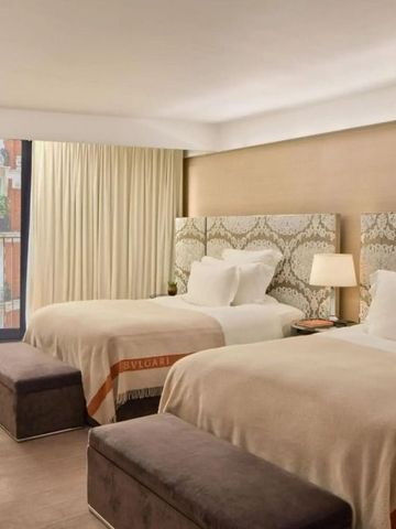 Elegantes Hotelzimmer mit zwei großen Betten und modernem Dekor