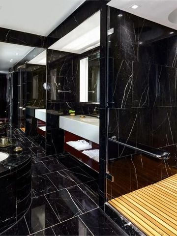 Elegantes Badezimmer mit dunklen Marmorelementen und hochwertigen Armaturen