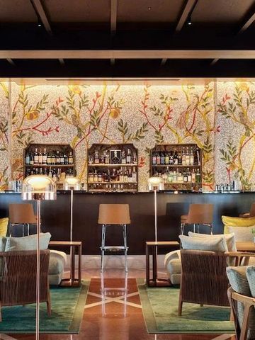 Elegante Hotelbar mit floraler Wandverzierung und gemütlicher Sitzanordnung