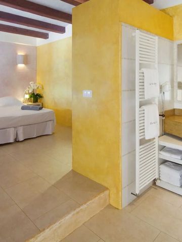Hotelzimmer mit offenem Badezimmer und gelben Wänden
