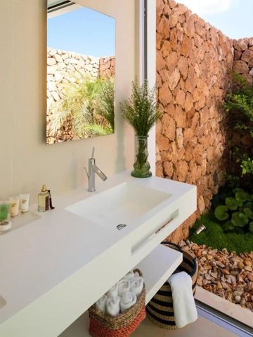 Luxuriöses Badezimmer mit Blick auf einen schönen Steingarten.