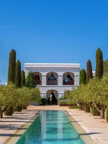 Große Villa mit Pool und Zypressen bei klarem Himmel