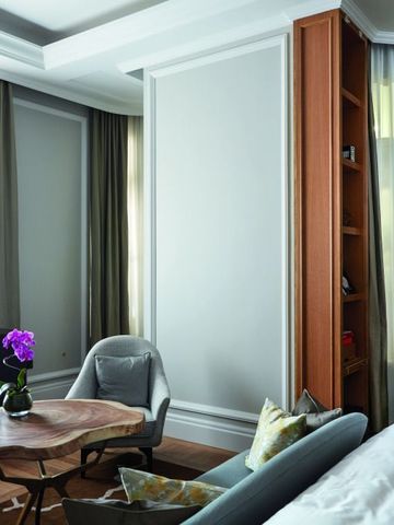 Hotelzimmer mit gemütlicher Sitzecke und Fliederblume auf Tisch