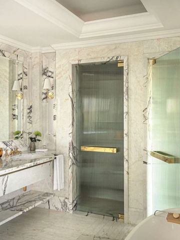 Luxuriöses Badezimmer mit Marmordekor und moderner Dusche