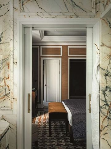 Luxuriöses Badezimmer mit Marmordekor und Blick auf das Schlafzimmer