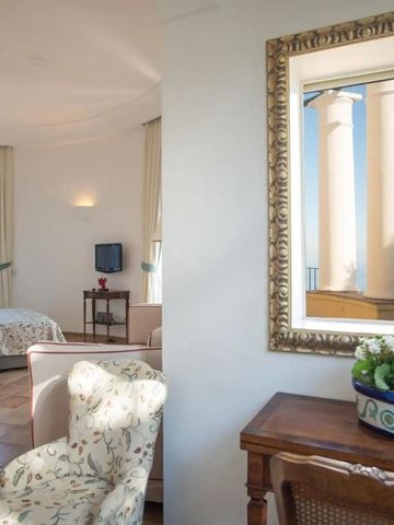 Einladende Suite mit klassischer Einrichtung und großem Fenster zur Terrasse