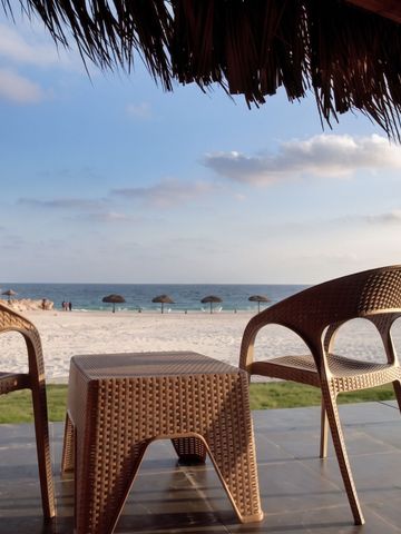 Terrasse mit Blick auf das Meer und Korbmöbeln