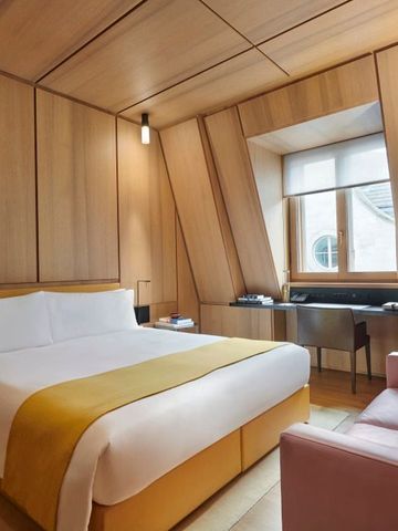 Luxuriöses Hotelzimmer mit Holzvertäfelung und großer Fensterfront