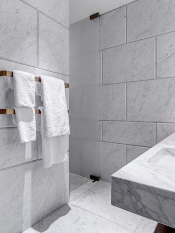 Modernes Badezimmer mit Marmorverkleidung und stilvollen Armaturen