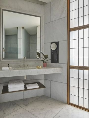 Badezimmer mit Marmorwänden und großen Spiegeln