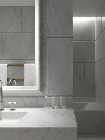 Minimalistisches Badezimmer mit Marmor und dezenter Beleuchtung