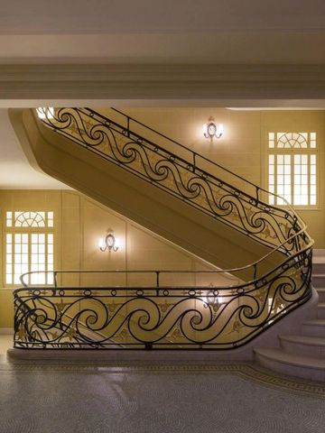 Elegante Treppe mit kunstvollen Geländern und sanfter Beleuchtung