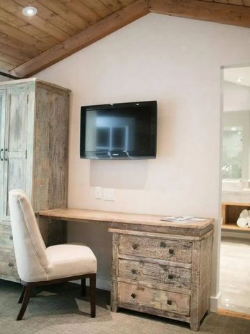 Gemütlicher Schreibtischbereich in einem Hotelzimmer mit rustikalen Holzmöbeln