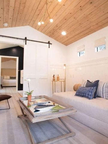 Gemütliches Wohnzimmer mit Holzdecke und elegantem Sofa
