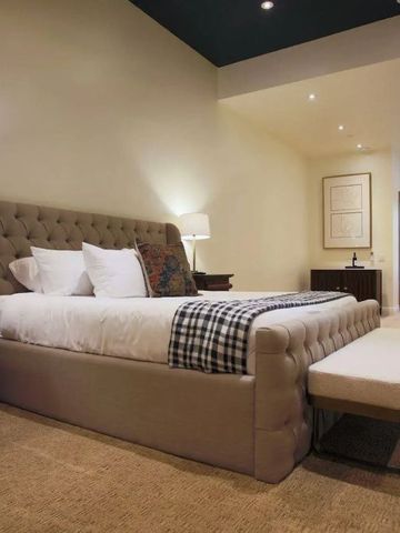 Luxuriöses Schlafzimmer mit gepolstertem Bett und moderner Beleuchtung