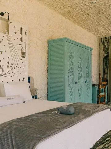 Geschmackvoll gestaltetes Hotelzimmer mit einzigartigem Wanddesign und Blau-Details