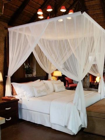 Geräumiges Schlafzimmer mit Himmelbett und Safari-Dekor
