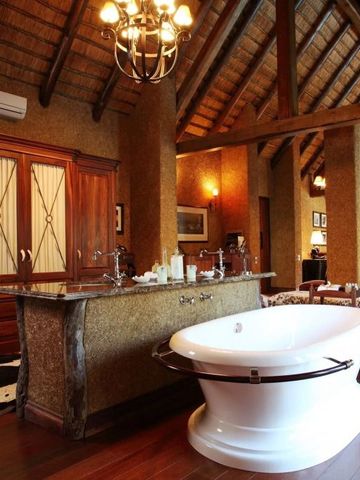 Luxuriöses Badezimmer mit freistehender Badewanne und edler Holzausstattung