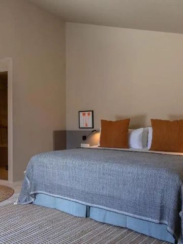 Gemütliches Schlafzimmer mit moderner Dusche im Hintergrund