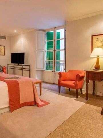 Stilvolles Zimmer mit Doppelbett, Schreibtisch und klassischer Dekoration im Hotel Can Cera.