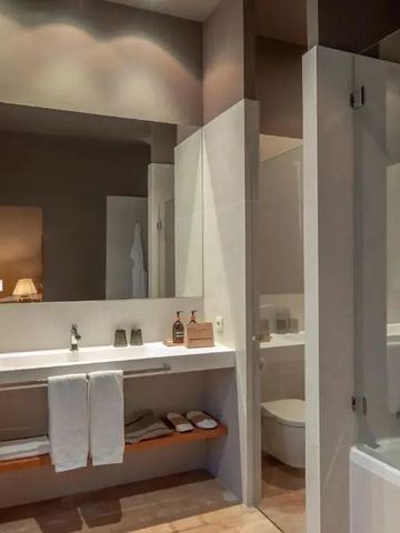 Badezimmer mit Dusche, Doppelwaschtisch und eleganter Beleuchtung