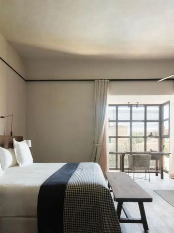 Helles Schlafzimmer mit Doppelbett und Balkon