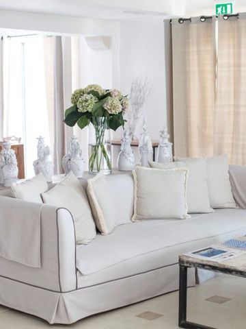 Helle Lounge mit Sofa, Pflanzen und dekorativen Vasen im Canne Bianche Lifestyle Hotel.