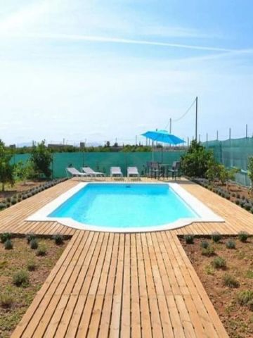 Langer Pool im Garten mit Liegestühlen
