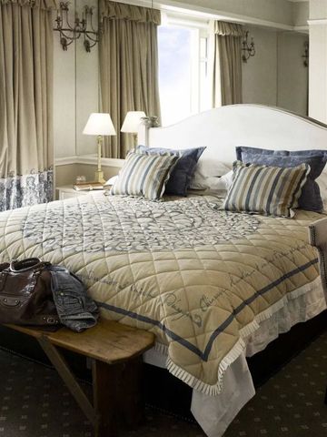 Luxuriöses Zimmer im Cape Grace Hotel mit gemütlichem Doppelbett und klassischer Einrichtung.