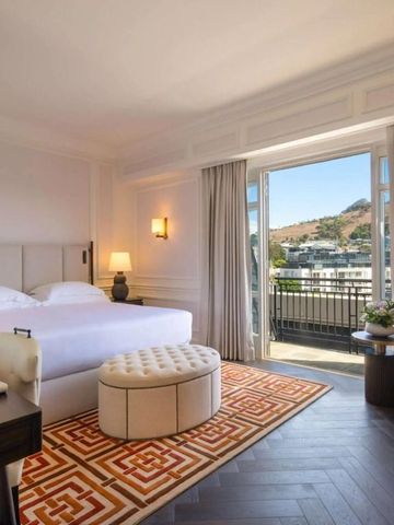 Helles Zimmer im Cape Grace Hotel mit Balkon und Blick auf die Umgebung.