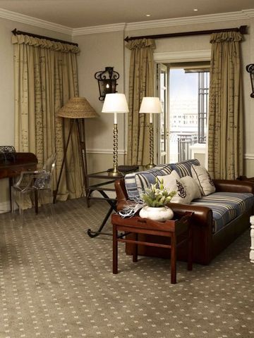 Eleganter Wohnbereich einer Suite mit klassischen Möbeln und großen Fenstern.