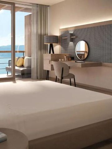 Hotelzimmer mit Doppelbett und Balkonblick auf einen See