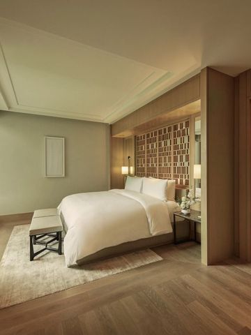 Luxuriöses Hotelzimmer mit großem Bett und eleganten Holzakzenten.