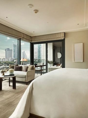 Luxuriöses Zimmer mit Panoramafenstern und Aussicht auf die Stadt.