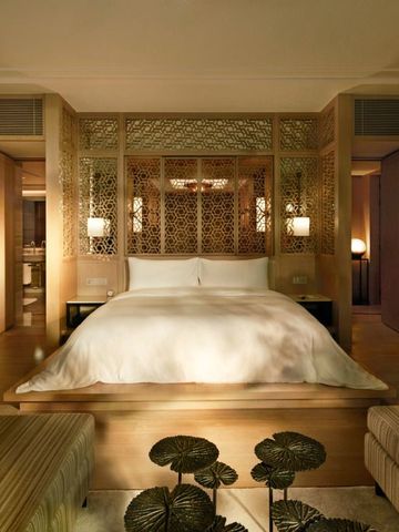 Geräumiges Schlafzimmer mit hellen Holzakzenten und gemütlichem Doppelbett im Capella Bangkok.