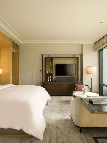 Helles Zimmer mit elegantem Doppelbett und Ausblick im Capella Bangkok.