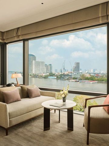 Komfortabler Lounge-Bereich mit großem Fensterblick im Capella Bangkok.
