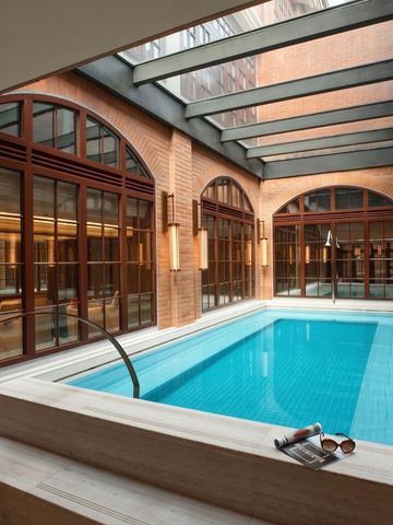 Luxuriöser Innenpoolbereich mit Glasdach und Brick-Elementen
