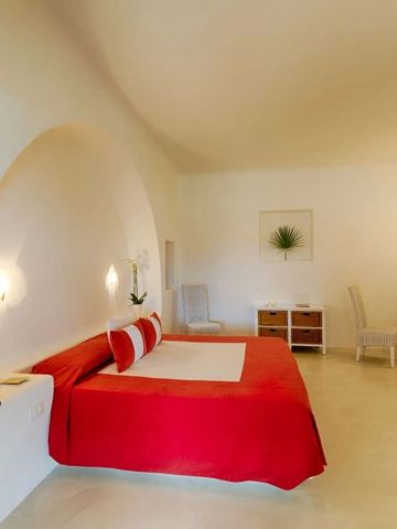 Einladendes Zimmer mit rotem Bettüberwurf und Wandnischenbeleuchtung