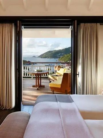 Hotelzimmer mit offenem Zugang zu einer Privatterrasse und Blick auf das Meer und die Hügel