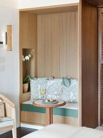 Gemütliche Leseecke mit Kissen und kleinem Tisch in einem eleganten Hotelzimmer