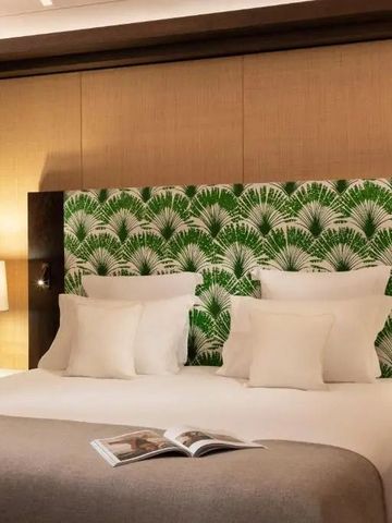 Hotelbett mit grünem, gemustertem Kopfteil und einladender Beleuchtung