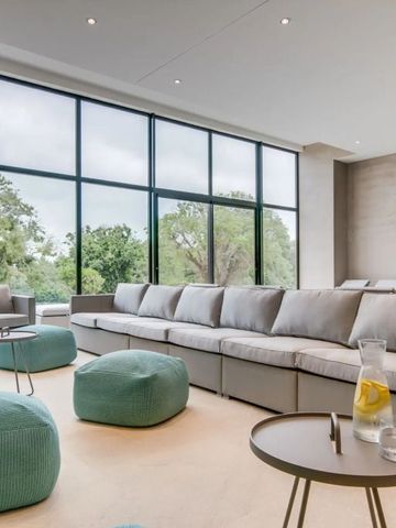 Großzügige Lounge mit modernen Möbeln und Blick auf grüne Natur