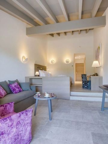 Elegantes Hotelzimmer mit heller Einrichtung und Holzbalkendecke