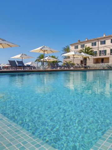 Klarer Pool mit Blick auf weißes Gebäude und Sonnenschirme