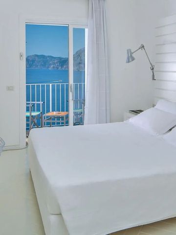 Helles Zimmer mit weißem Interieur und Balkonblick auf das Meer