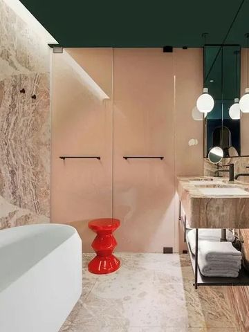 Luxuriöses Badezimmer mit Marmorwänden und freistehender Badewanne