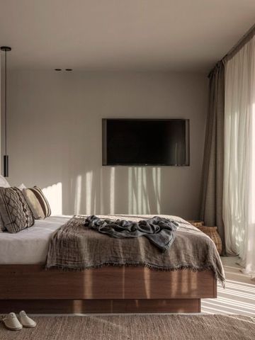 Lichtdurchflutetes Zimmer mit weichen Erdtönen und großen Fenstern