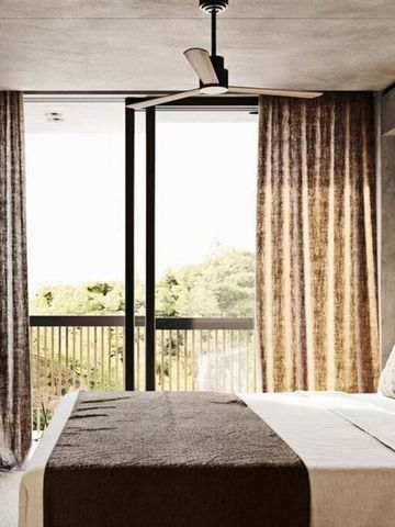 Schlafzimmer mit großen Fenstern und Blick auf die Natur