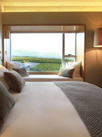 Luxuszimmer mit großem Fenster und Blick auf Weinberge